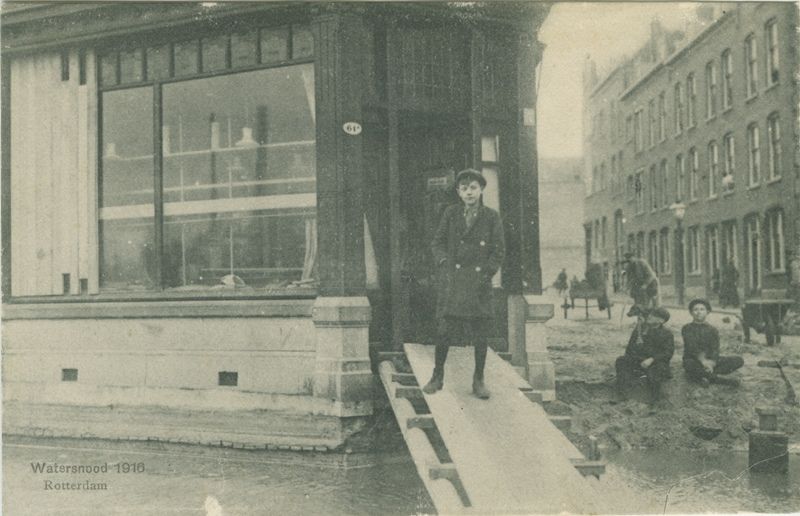 Prentbriefkaart van de schade veroorzaakt door de stormvloed van 13 januari, zoals aan de West-Varkenoordseweg hoek Beukelaarstraat.