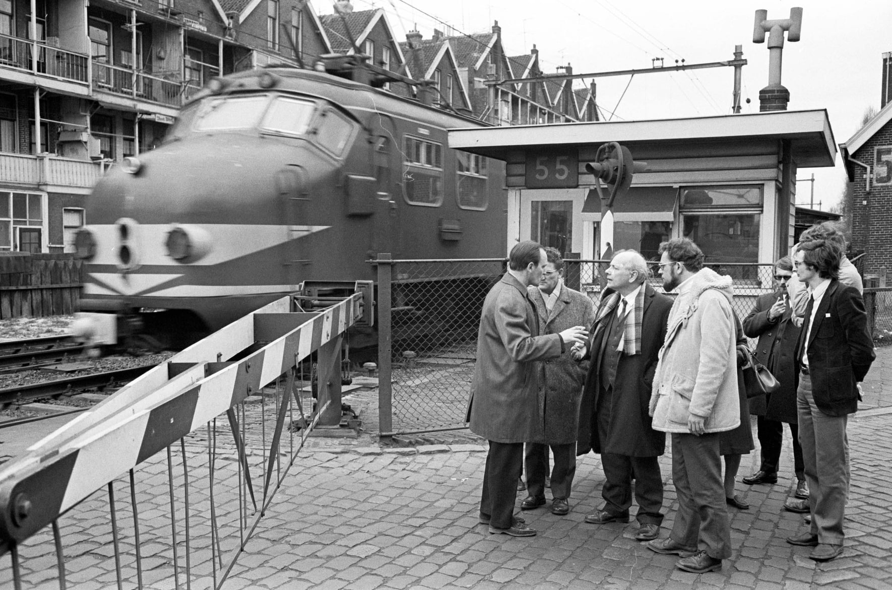 Joop den Uyl bezoekt de spoorwegovergang tussen de Rosestraat en Oranjeboomstraat, in de wijk Feijenoord, rond 1970.
