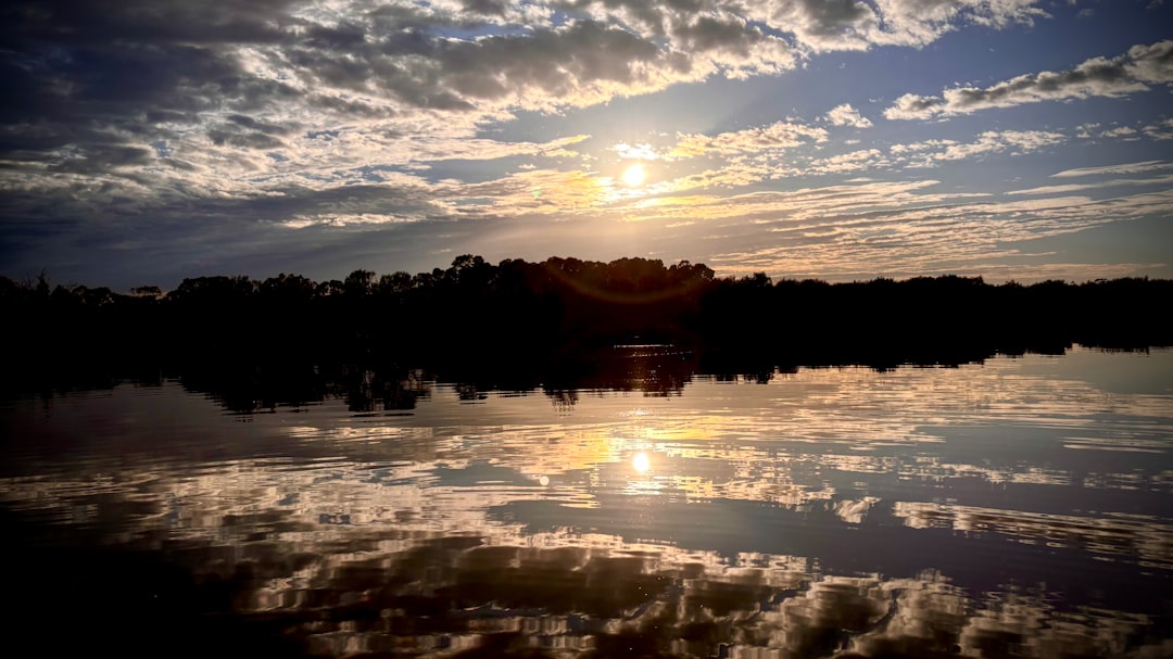 Terwijl de zon door de wolken komt, verandert de Maas in een spiegel...
